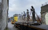 A large lorry transporting six stone statues
