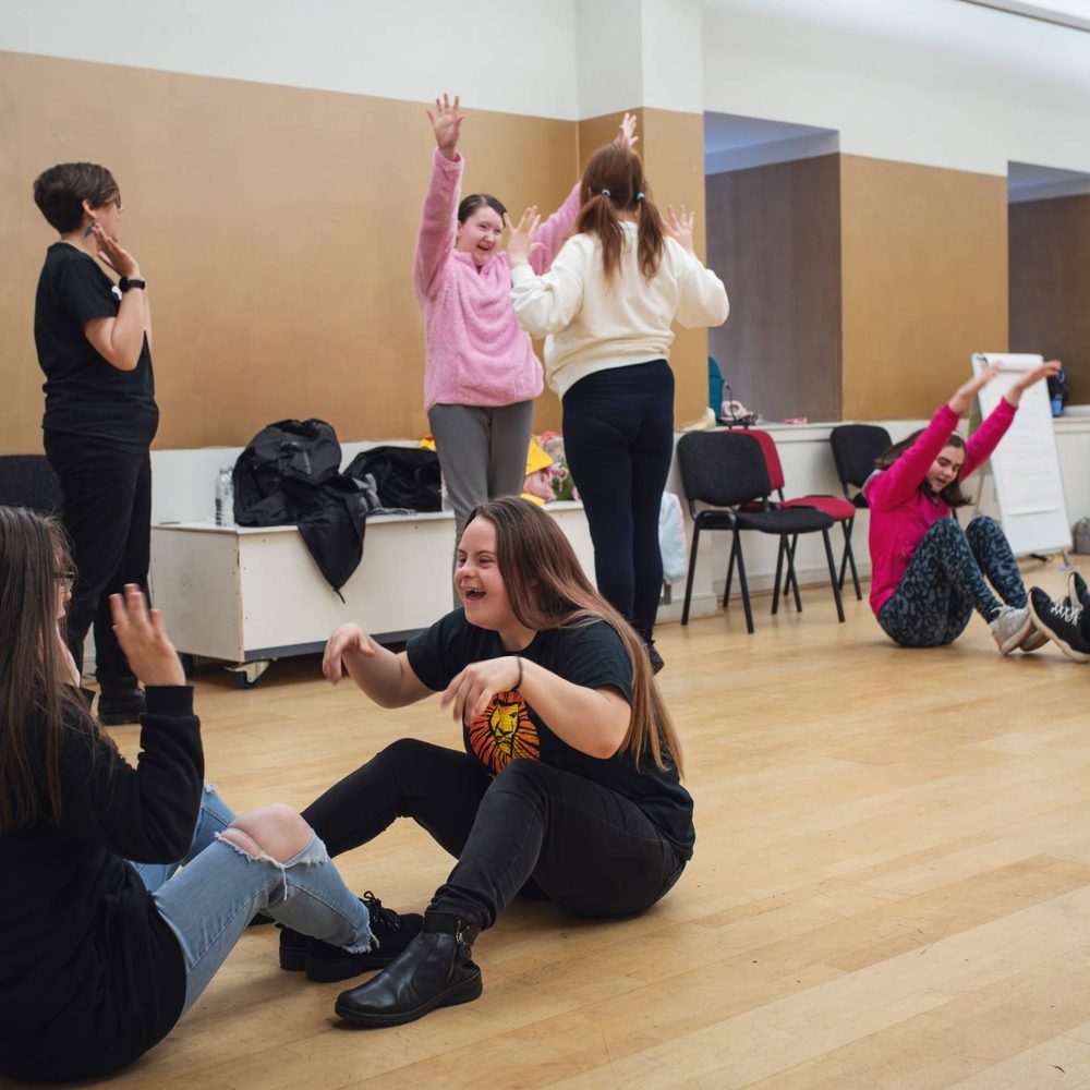 A group of learning disabled young people playing a drama game.