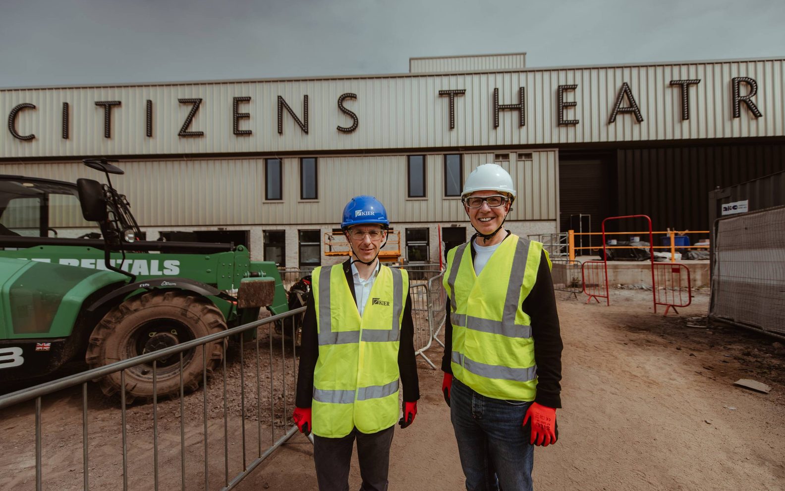 Alex McGowan and Johnathan Syson standing outside the Citizens Theatre. They are wearing full PPE.