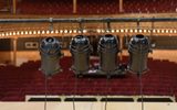 Stage lights with the red seats of the auditorium visible behind.