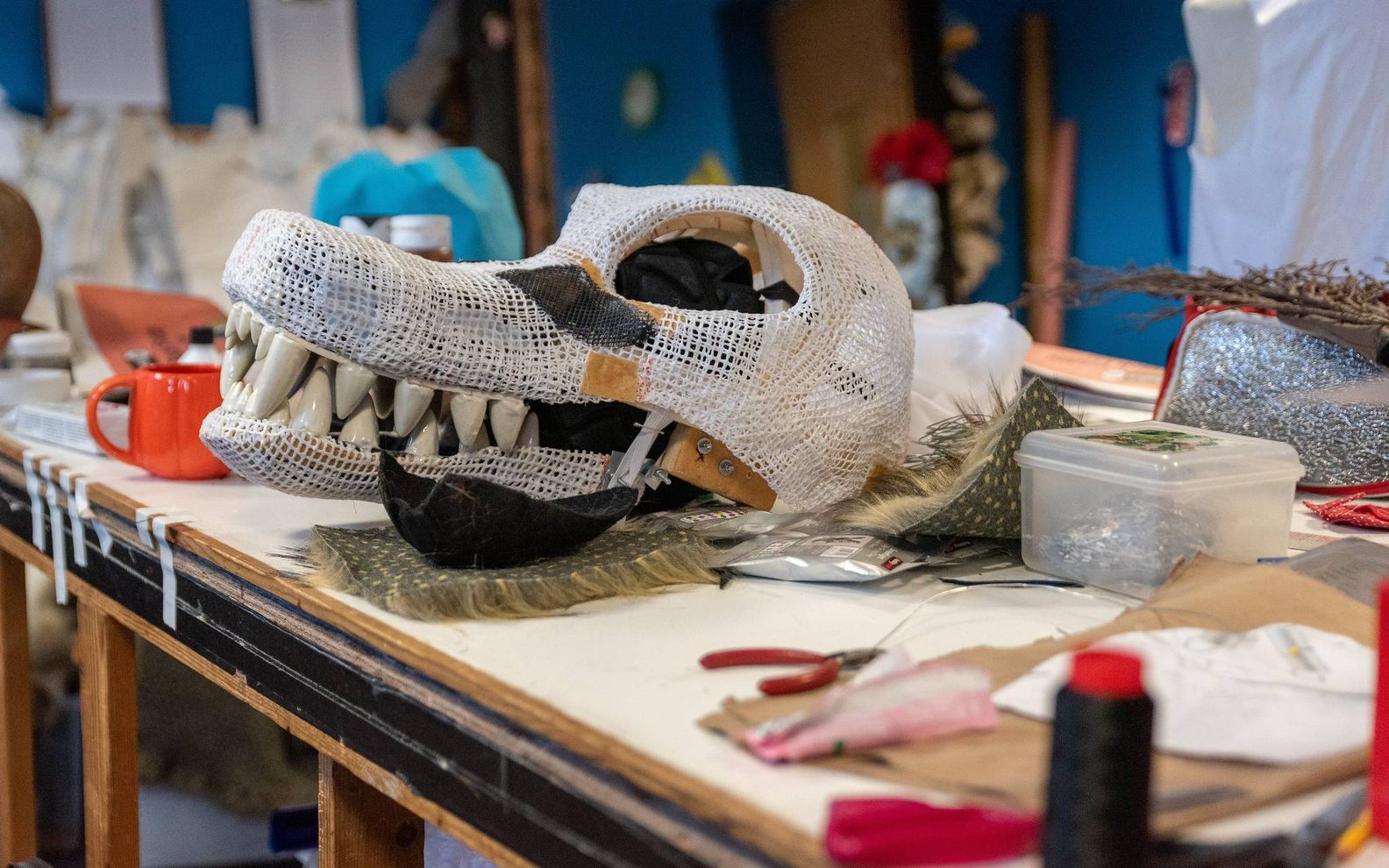 A workshop bench with a mask that's been half made.