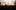 Celtic-Connections-generic-aspect-ratio-1600-1000 A crowed witharms in the air looking up at a bright stage