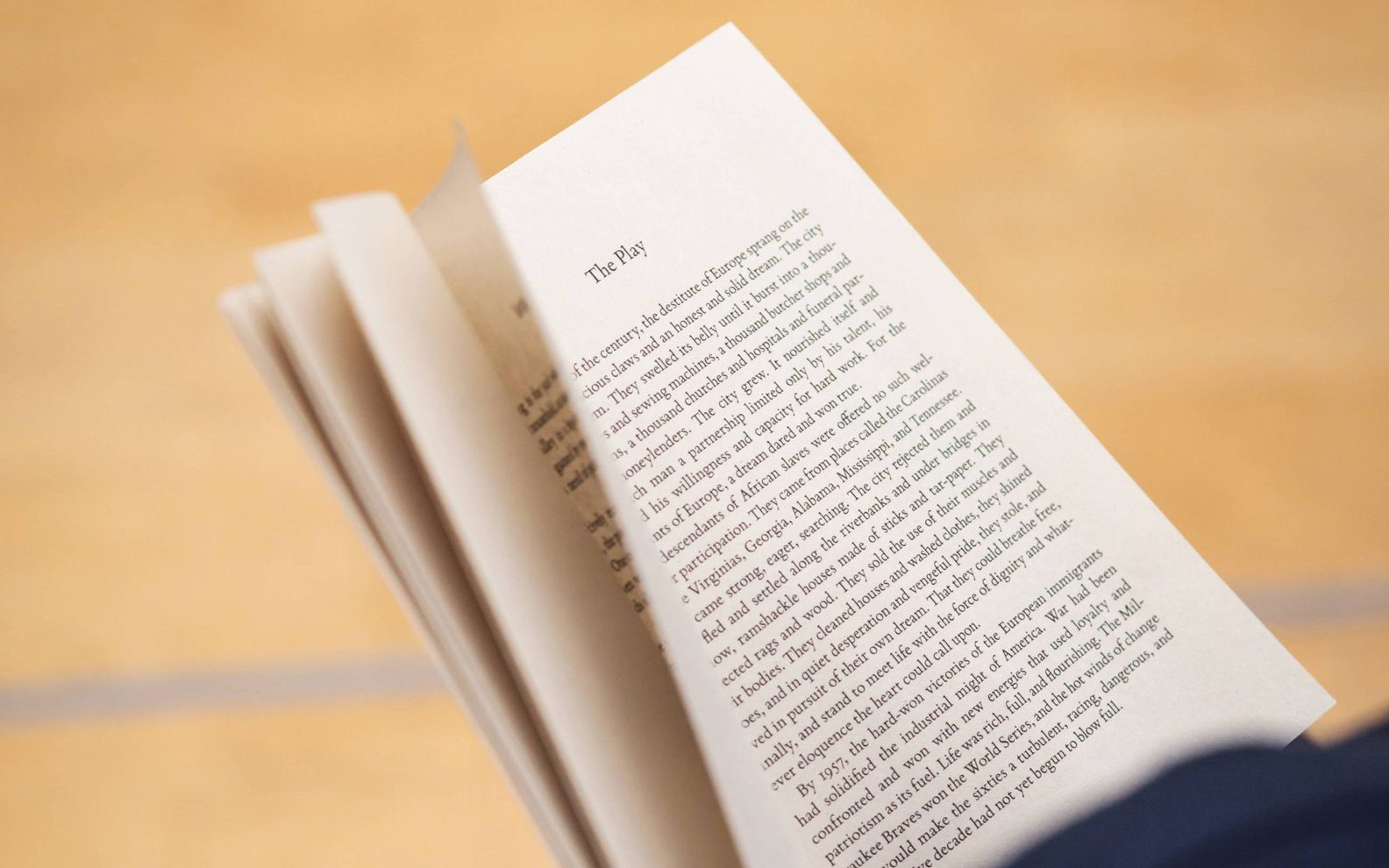 A play reading session. An open book being held in a person's hands.